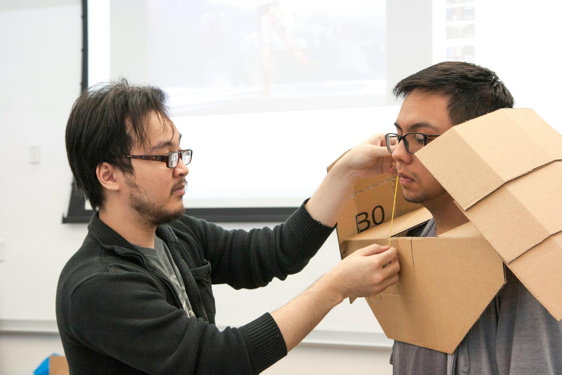 Uczniowie robią kartonowy strój, współpracując na uczelni