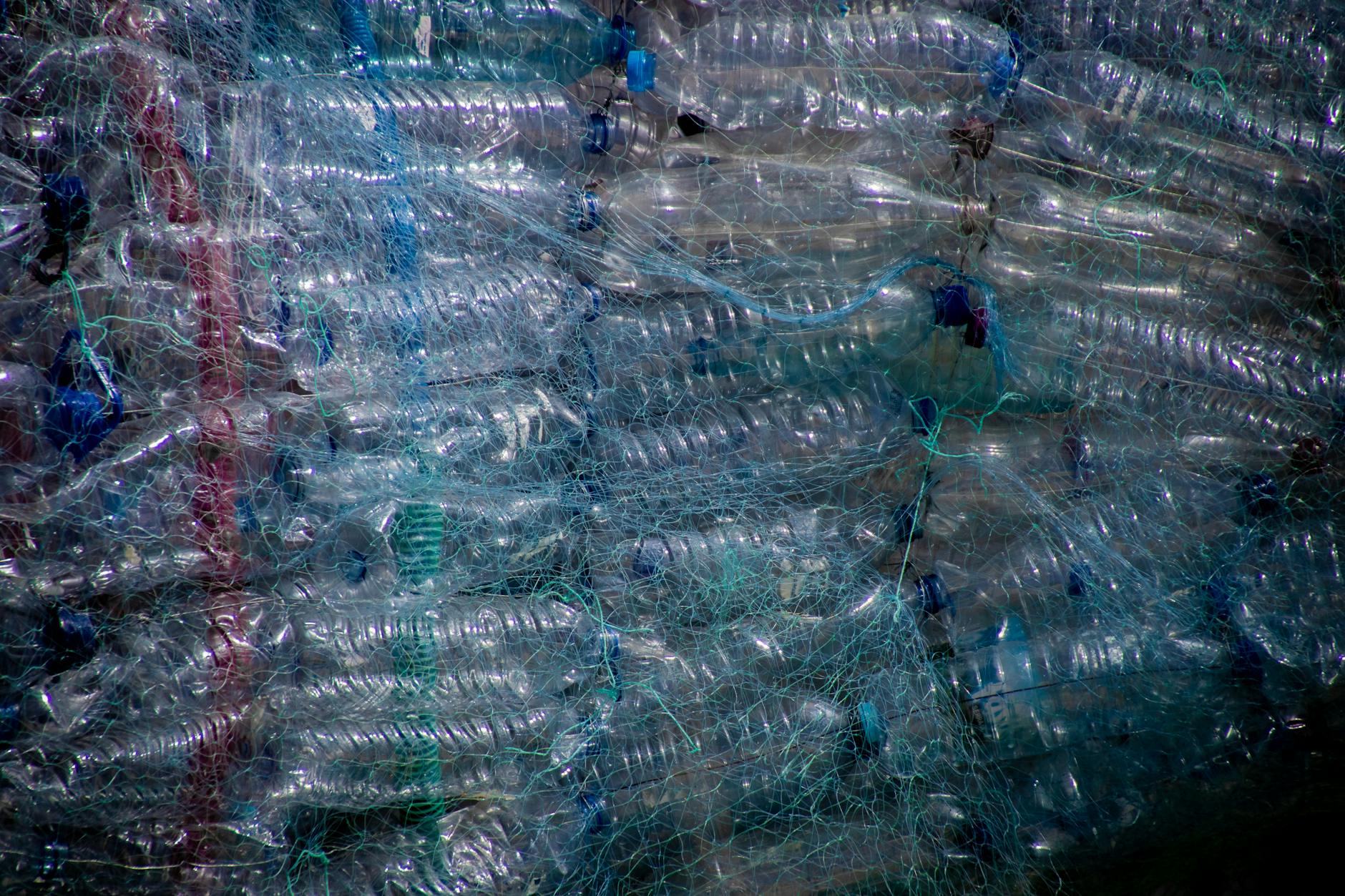 Plastikowe butelki w siatce, przygotowane do recyklingu