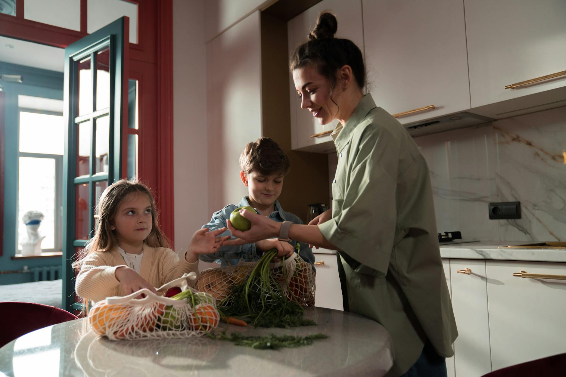 Mama i dzieci kroją świeże warzywa w nowoczesnej, ekologicznej kuchni
