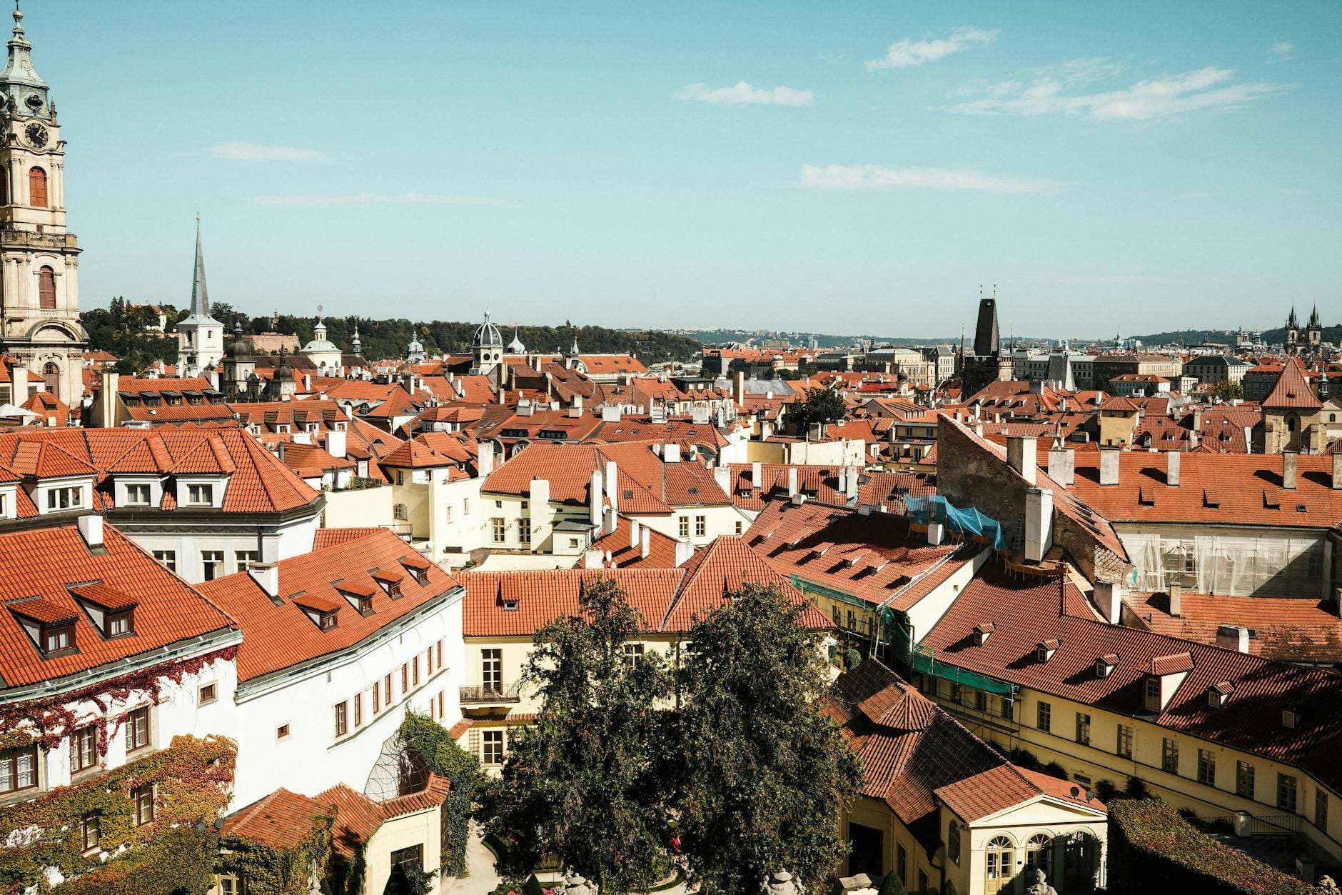 Czerwone dachy i zabytkowe kamienice Pragi w słoneczny dzień