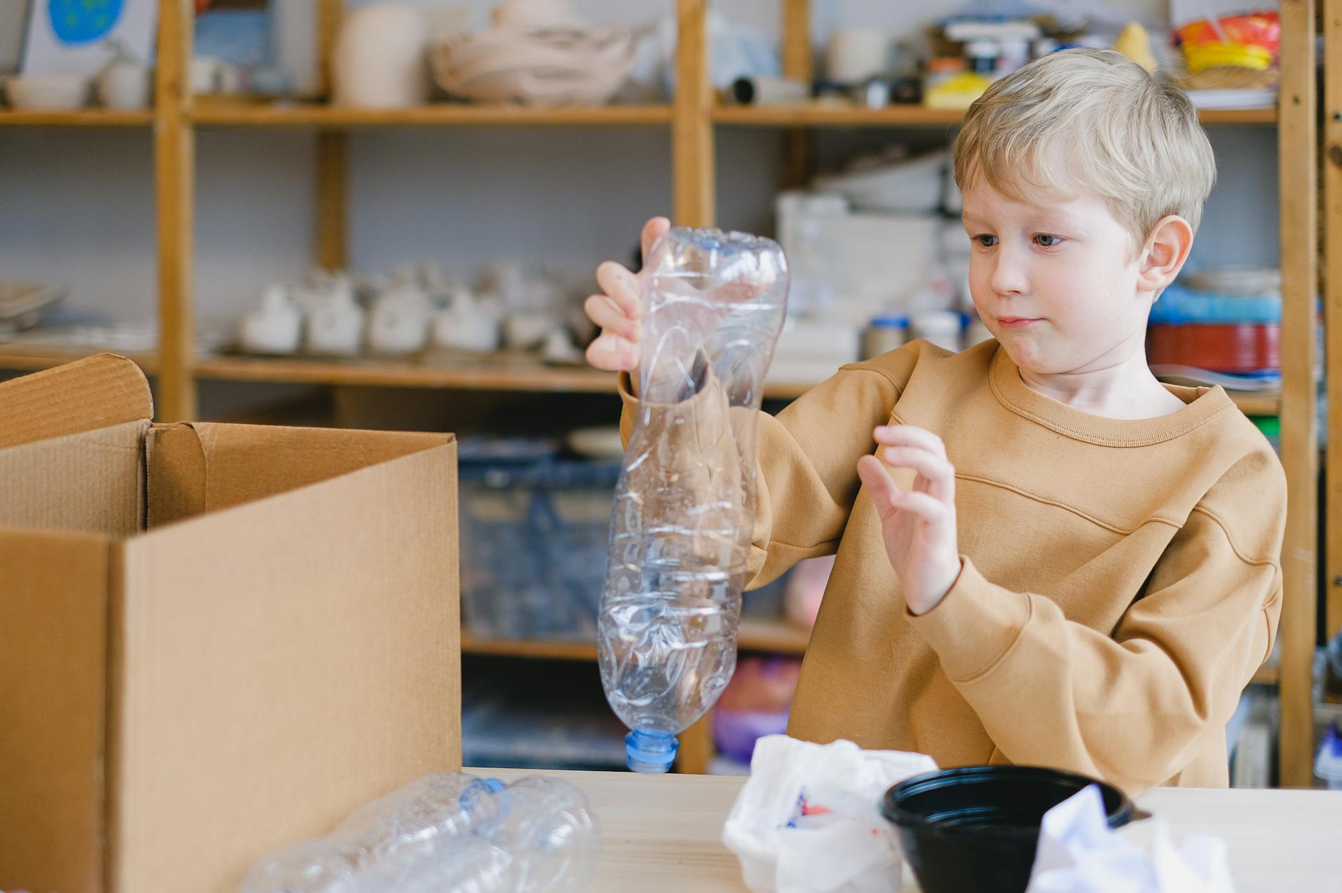 Dziecko segregujące plastikowe butelki do recyklingu