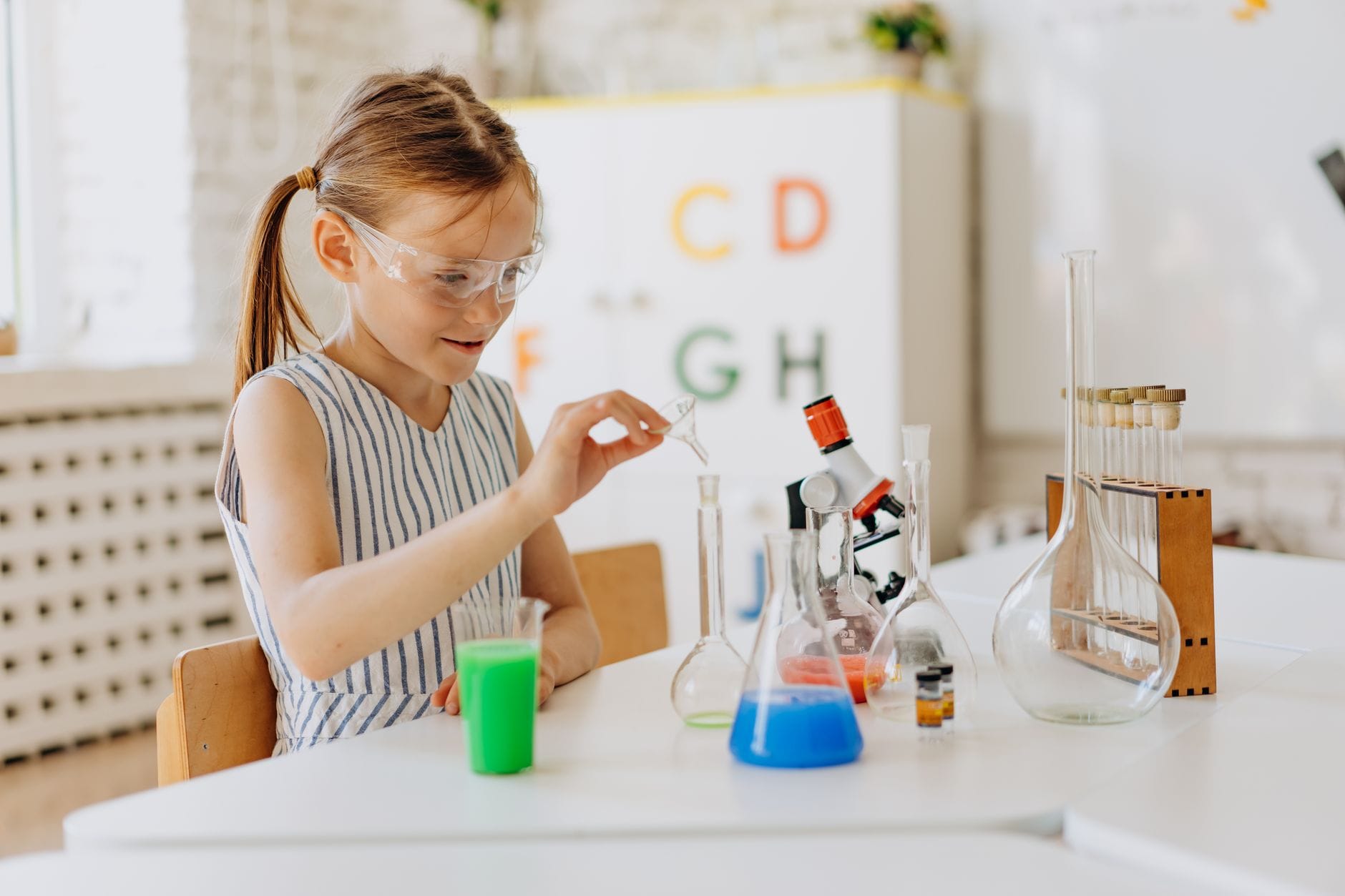 Dziewczynka wykonuje doświadczenia chemiczne w domowym laboratorium
