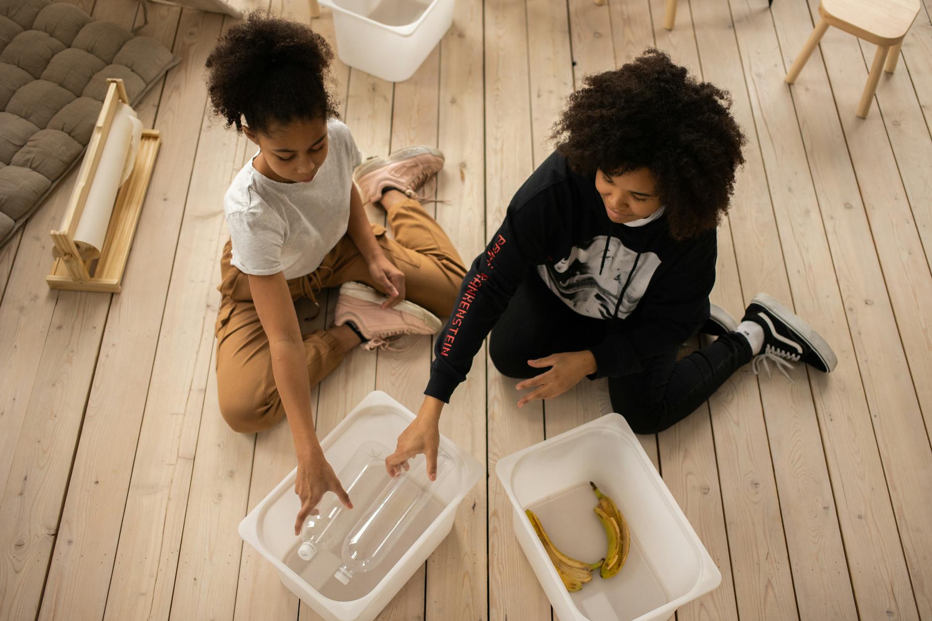 Mama i córka na podłodze wspólnie segregują plastik i bioodpady