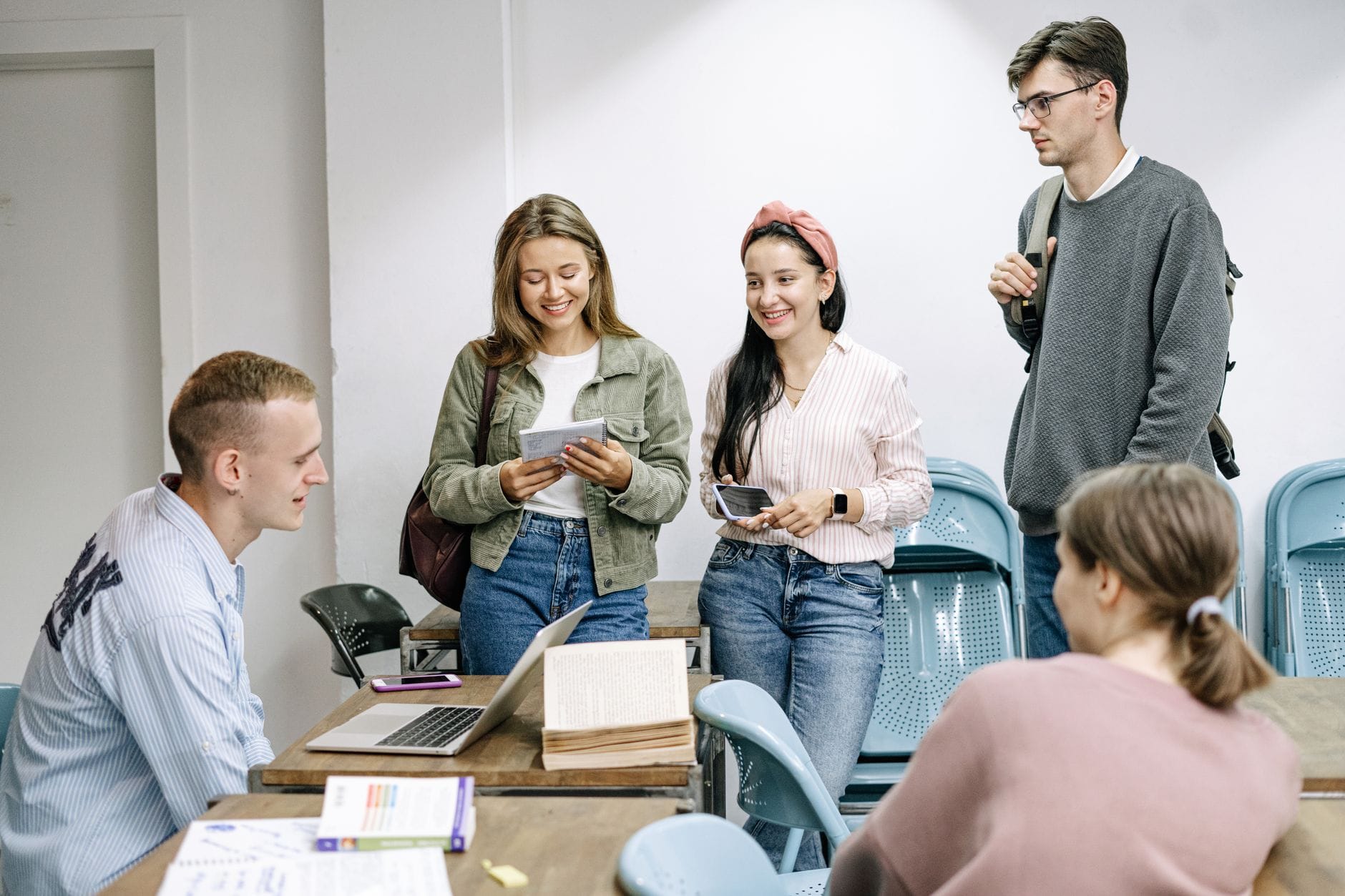 Uczniowie pracują zespołowo nad projektem przy stole w sali szkolnej
